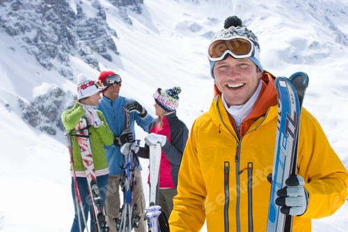 Preview: A Handsome Adventurous Woman Holding Skis While Smiling At The Camera On A Mountain Top With Other
