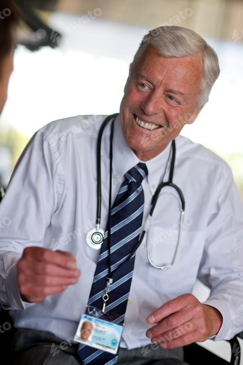 Preview: A Middle-Aged Doctor With A Stethoscope Around His Neck Smiling While Having A Conversation With