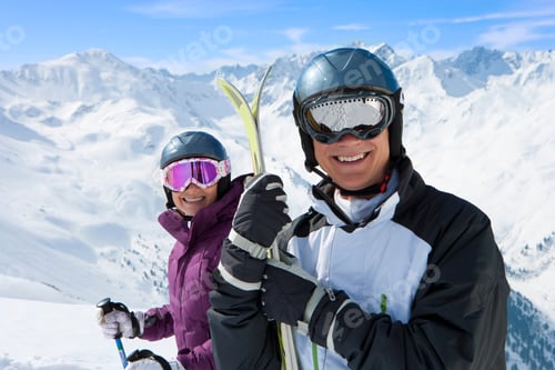 Preview: A Portrait Of An Adventurous Senior Couple Wearing Goggles And Carrying Skis On A Snowy Slope With