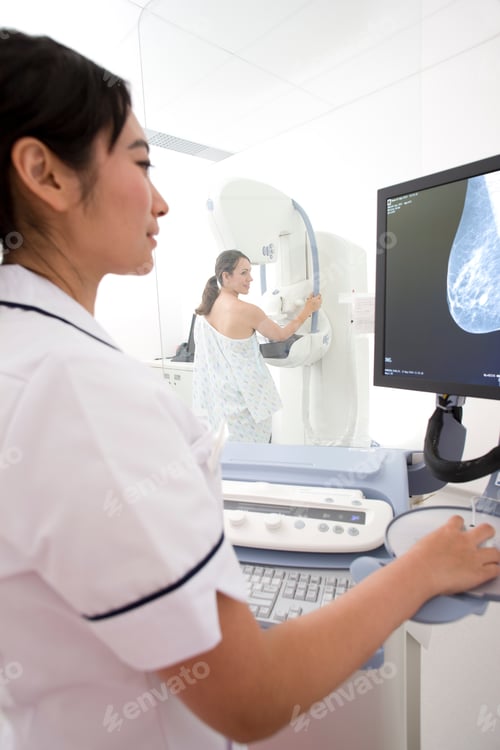 Preview: A Vertical Rear View Of A Woman Taking A Mammogram X-Ray Test In The Clinic While Being Examined By