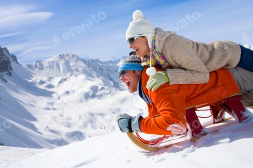Preview: A Side View Of A Happy Couple Having Fun While Sliding Downhill Together Over Snowy Slope Using A