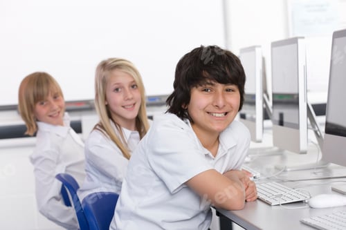 Preview: Smart Students In Computer Class Smiling At The Camera While Working On Desktop Computers