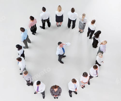 Preview: Overhead Shot Of A Businessman With Hands On His Temple Looks At The Camera Surrounded By His