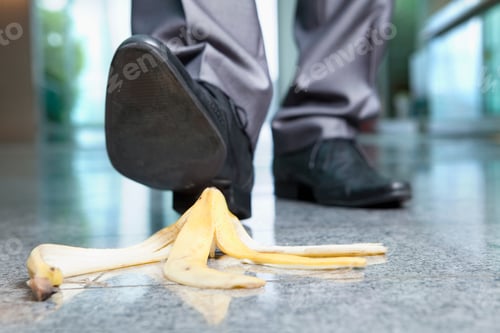 Preview: A Horizontal Closeup Of The Foot Of A Businessman Stepping On A Banana Peel
