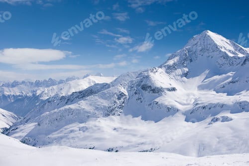 Preview: A Beautiful View Of A Snowy Mountain Range With A Blue Sky.