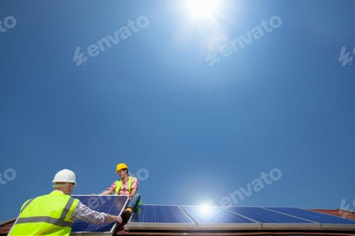 Preview: Sun Shines Over Two Construction Workers Installing A Solar Panel On A Rooftop On A Clear Sunny Day