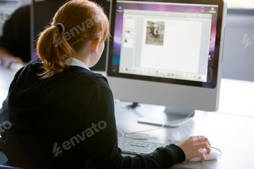 Preview: A Rear View Of A Teenage Girl In Uniform Using A Computer In School