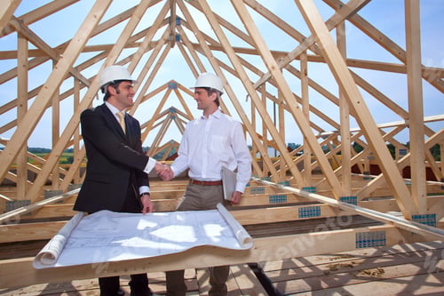 Preview: A Wide View Of Two Smiling Architects With Blueprints Shaking Hands Over An Agreement At A