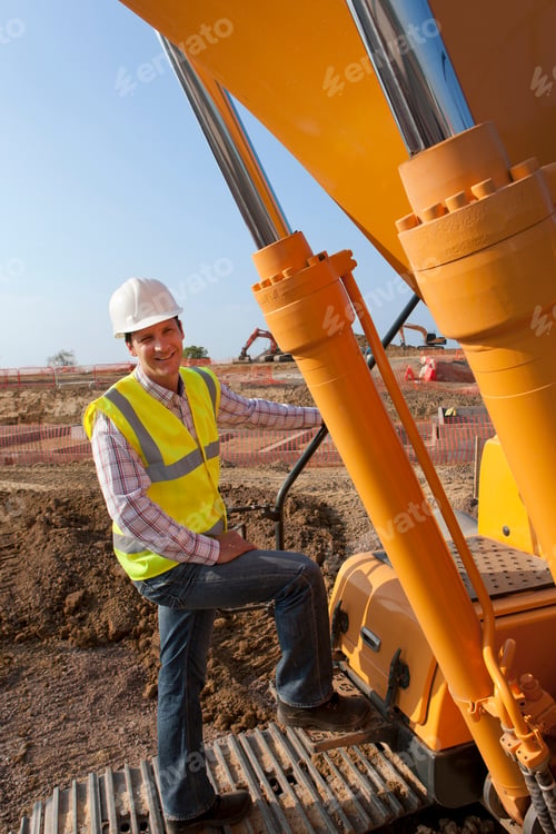 Preview: A Portrait Shot Of A Construction Worker Smiling At Camera While Standing On A Construction Vehicle.