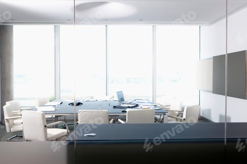 Preview: A Wide View Of A Conference Room Through A Glass Wall With Laptop And Papers Lying On The Table