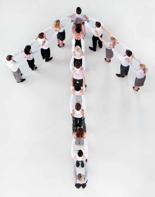 Preview: Vertical Overhead Shot Of Businesspeople Standing In Formation Of An Upward Arrow With Hands On