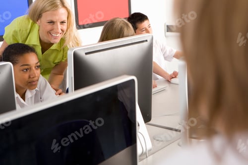 Preview: A Lady Teacher Helping Students Working On A Desktop Computers In School Computer Lab