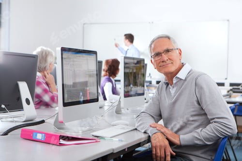 Preview: A Medium Shot Of A Senior Man With Gray Hair Looking At Camera While Using A Computer In A Lab With