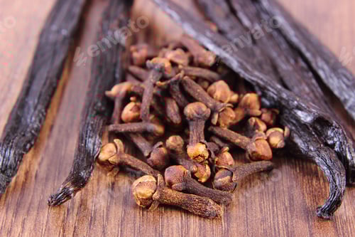 Preview: Closeup Of Fresh Cloves And Fragrant Vanilla Sticks Pods On Wooden Board. Seasoning For Cooking Or