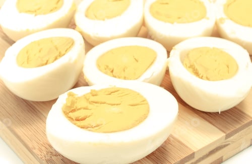 Preview: Halves Of Cooked Eggs On Wooden Cutting Board. Sliced Egg