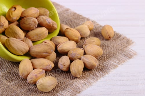 Preview: Pistachio Nuts In Glass Bowl On White Wooden Table, Healthy Food And Nutrition