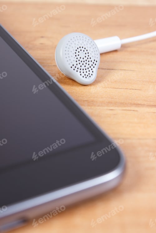 Preview: Mobile Phone, Smartphone With Headphones On Wooden Table