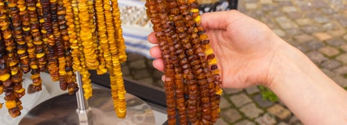 Preview: Hand Of Woman With Orange Shiny Amber Necklace, Shopping Jewelry And Womanly Accessories On Stall