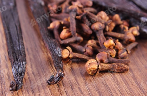 Preview: Closeup Of Fresh Cloves And Fragrant Vanilla Sticks Pods On Board, Seasoning For Cooking Or Baking
