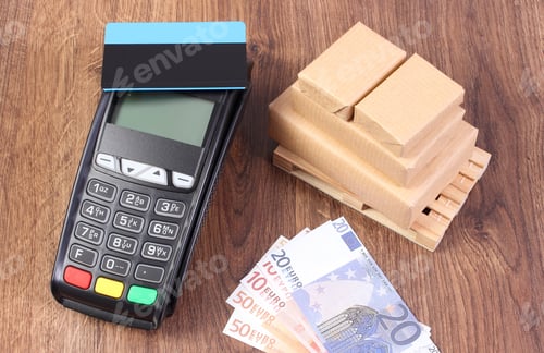 Preview: Payment Terminal With Contactless Credit Card, Currencies Euro And Small Wrapped Boxes On Wooden