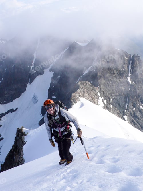 Aperçu: Mountain Climber On A Steep And Narrow Snow Ridge Leading To A High Peak In The Swiss Alps