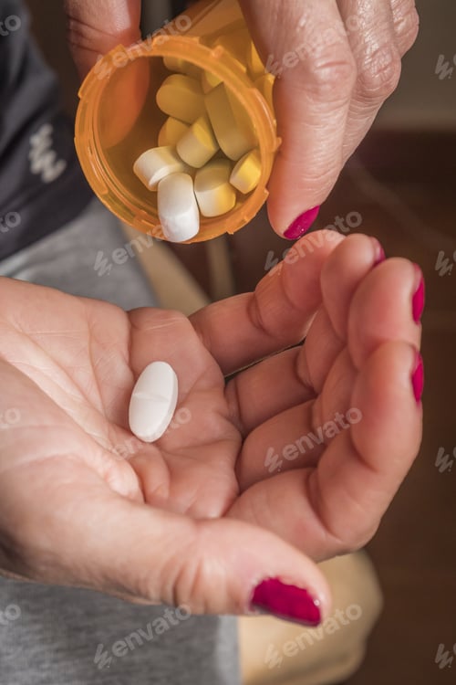 Preview: Women Take White Capsule With Left Hand From A Ambar Transparent Bottle