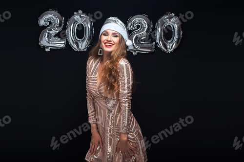 Preview: Happy Young Woman In Santa Hat With Metallic 2020 Balloons On Black Background. New Year