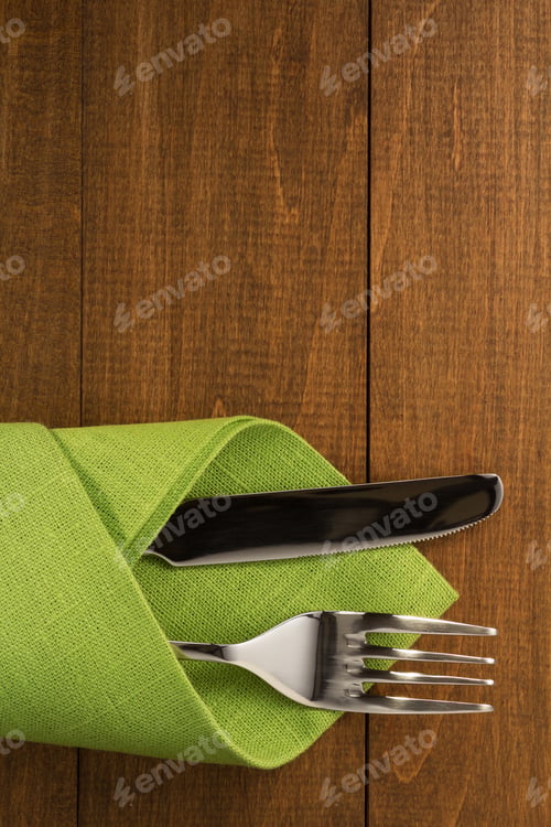 Preview: Knife And Fork At Napkin On Wooden Background