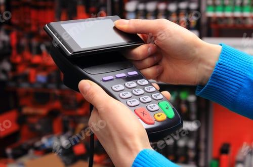 Preview: Hand Of Woman Paying With Nfc Technology On Mobile Phone In An Electrical Shop, Credit Card Reader