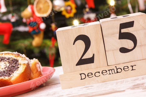 Visualização: Data 25 de dezembro, bolo tradicional de sementes de papoula no prato e árvore de Natal com luzes e