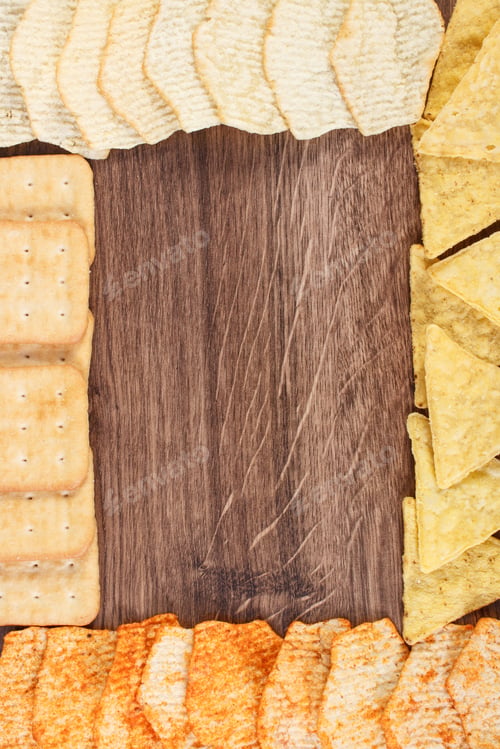 Preview: Frame Of Crunchy Cookies And Potato Crisps On Rustic Board, Concept Of Restriction Eating Unhealthy