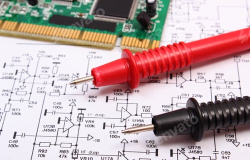 Preview: Printed Circuit Board With Electrical Components And Cable Of Multimeter On Construction Drawing Of