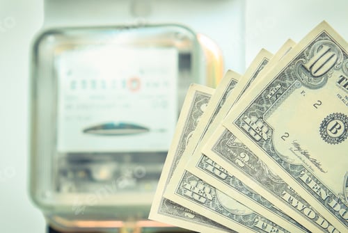 Preview: Currencies Dollars And And Electric Energy Meter Old Electromechanical Type In Background. Energy