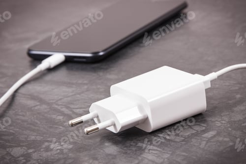 Preview: Black Mobile Phone With Connected White Plug Of Charger. Smartphone Charging