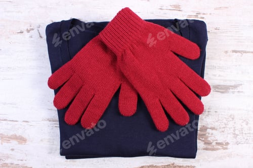 Preview: Pair Of Woolen Gloves And Navy Blue Sweater For Woman On Old Rustic Wooden Background, Womanly