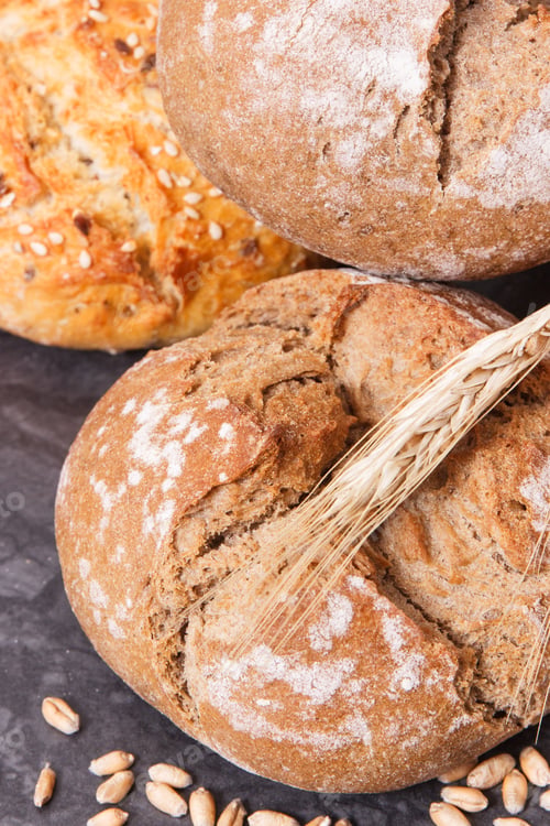 Preview: Fresh Crunchy Wholegrain Rolls Or Bread With Seeds And Ears Of Rye Grain