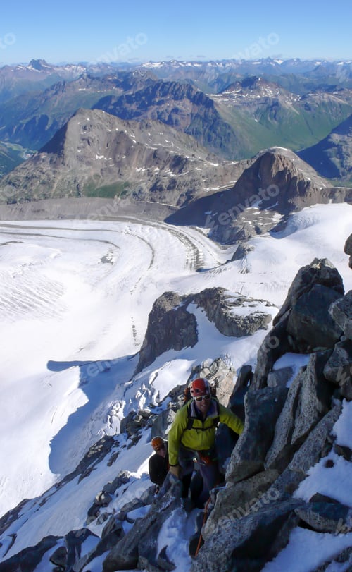 Preview: Mountain Guide Leading Male Client To The Summit Of A High Alpine Peak On A Beautiful Summer Day