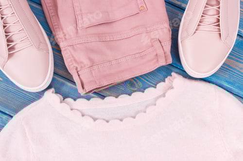 Preview: Womanly Pink Leather Shoes, Sweater And Pants Lying On Old Blue Boards