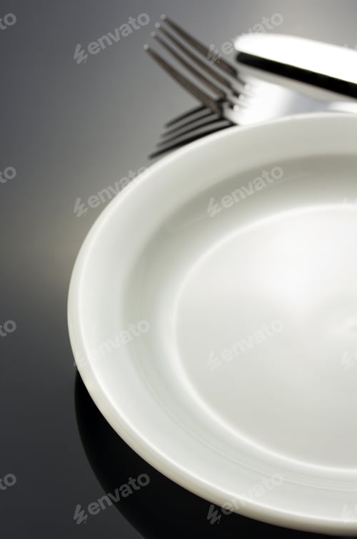 Preview: Knife And Fork At Plate On Black Background