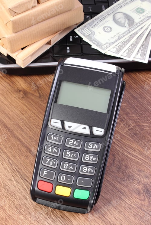 Preview: Payment Terminal, Currencies Dollar, Laptop And Small Wrapped Boxes On Wooden Pallet, Paying For