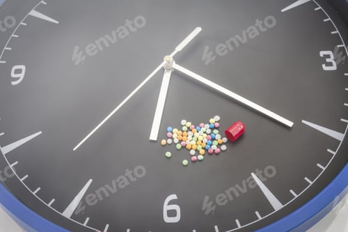 Preview: Open Red Capsule Pill With Ball Color Drug On Black Clock Background