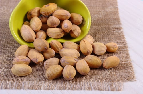 Preview: Pistachio Nuts In Glass Bowl On White Wooden Table, Healthy Food And Nutrition