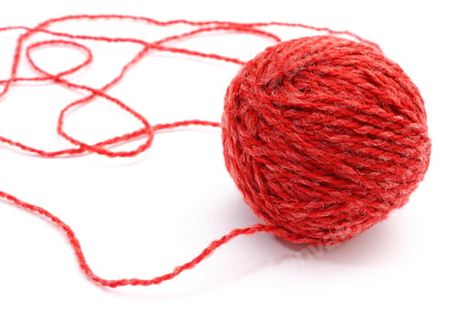 Preview: Closeup Of Entangled Red Wool And Wool Ball On White Background.