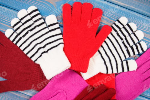 Preview: Colorful Woolen Gloves For Woman On Blue Boards, Warm Clothing For Autumn Or Winter Concept