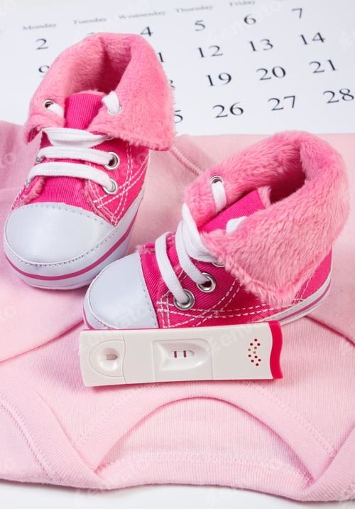Preview: Pregnancy Test With Positive Result And Clothing For Newborn On Calendar, Baby Shoes, Bodysuits