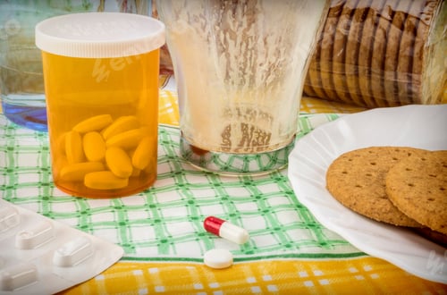 Preview: Medication During Breakfast, Capsules Next To A Glass Of Water, Conceptual Image, Horizontal