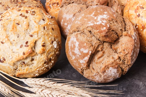 Preview: Fresh Crunchy Wholegrain Rolls Or Bread With Seeds And Ears Of Rye Grain