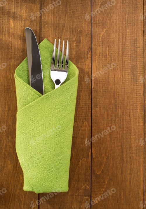 Preview: Knife And Fork At Napkin On Wooden Background