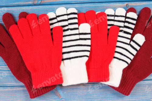 Preview: Colorful Woolen Gloves For Woman On Blue Boards, Warm Clothing For Autumn Or Winter Concept