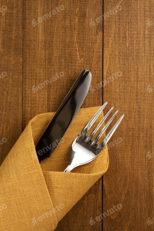 Preview: Knife And Fork At Napkin On Wooden Background